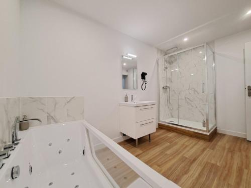 une salle de bain blanche avec une baignoire et une douche dans l'établissement Turin - Appartement charmant et moderne, à Reims