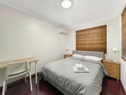 a bedroom with a bed with a desk and a table at MetaWise Cozy Family Room in Shared Home Free Parking in Castle Hill