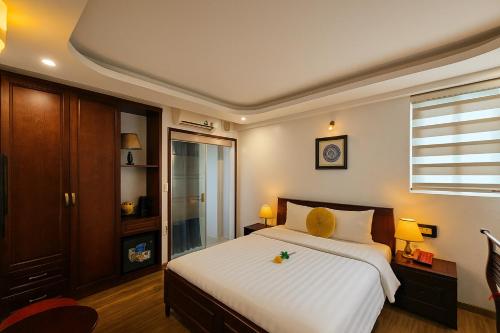 a bedroom with a large white bed and a window at Hanoi Siva Luxury Hotel & Travel in Hanoi