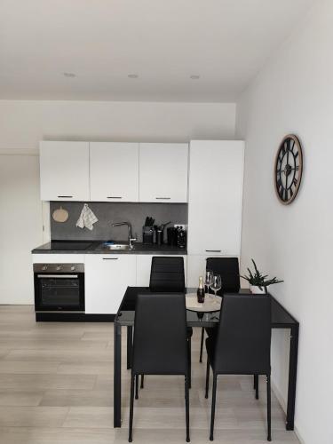 a kitchen with a table and black chairs and a counter at Maison 40 in Albiano