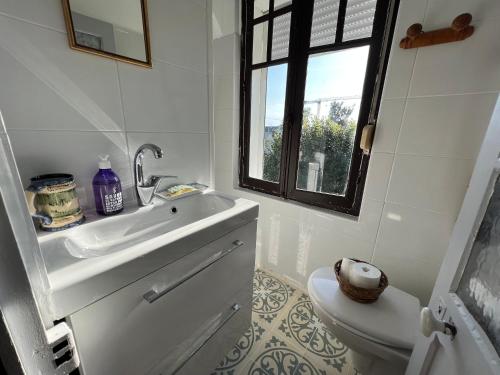 a bathroom with a sink and a toilet at maison proche bourg et plages 7 personnes jardin Ker Emmanuel in Erquy