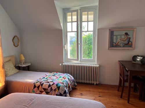 a bedroom with two beds and a window and a desk at maison proche bourg et plages 7 personnes jardin Ker Emmanuel in Erquy