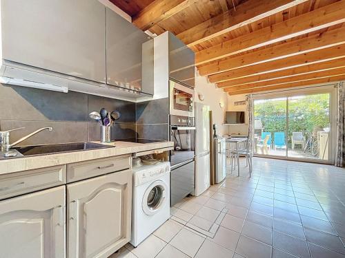 une cuisine avec un évier et un lave-vaisselle dans l'établissement La Rive - Maison de vacance proche de la plage, à Leucate