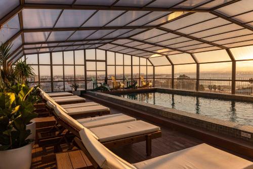 a large swimming pool with benches and tables in a building at Upon Vila - Alcochete Hotel in Alcochete