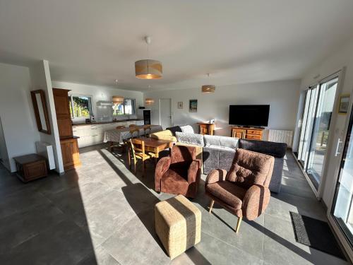 un salon avec un canapé, des chaises et une table dans l'établissement 101 - Maison 4p à 1km de la plage des Sables-D'or., à Fréhel