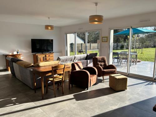 un salon avec un canapé, une table et des chaises dans l'établissement 101 - Maison 4p à 1km de la plage des Sables-D'or., à Fréhel