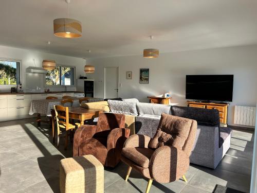 un salon avec un canapé, des chaises et une table dans l'établissement 101 - Maison 4p à 1km de la plage des Sables-D'or., à Fréhel