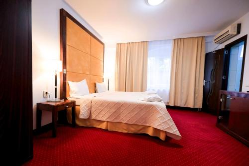 a hotel room with a bed and a large window at Visconti Militari in Bucharest