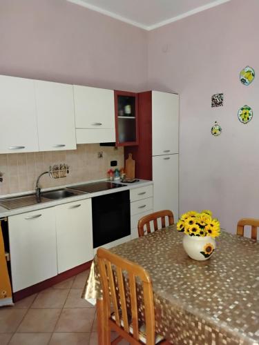 a kitchen with a table with a vase on it at L'albero di limoni sul mare di Pizzo in Pizzo