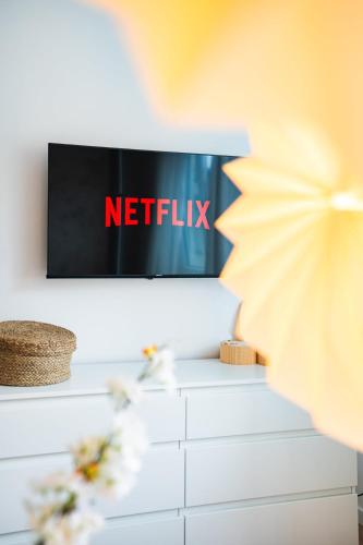 a television with the netflix sign on a wall at 2 BR Apartment - ZENTRAL - KÜCHE - BALKON - WIFI - NETFLIX - BUSINESS - KAFFE - PARKHAUS in Wiesbaden
