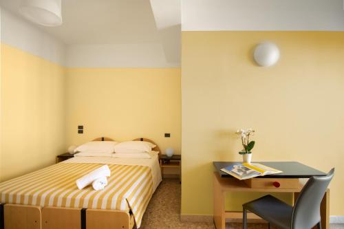 a hotel room with a bed and a desk at Hotel Marcelli in Numana