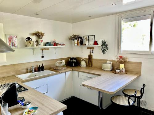 une cuisine avec des armoires blanches et un comptoir en bois dans l'établissement Cozy apartment 75m2, garden, beach and center 15 min, à Montpellier
