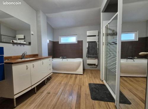 une grande salle de bains avec deux lavabos et deux baignoires dans l'établissement La Quarantaine, à Quarante