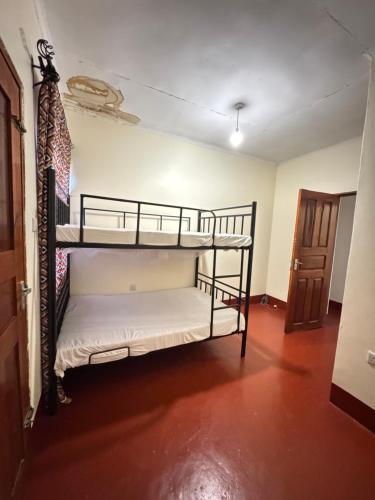 a bedroom with two bunk beds in a room at The Hut Hostel in Arusha