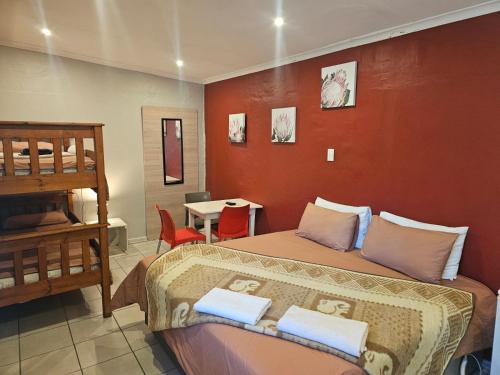 a bedroom with a bed and a table with chairs at Stay at 126 in Bloemfontein