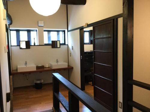 a bathroom with two sinks and a mirror at Honmachi Juku in Hikone