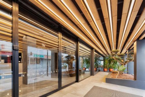a lobby of a building with wooden ceilings and plants at Eurostars Puerto de Ibiza in Ibiza Town