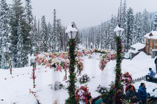 a wedding ceremony in the snow with flowers and lights at The Khyber Himalayan Resort & Spa in Gulmarg