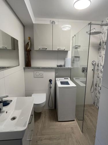 a bathroom with a toilet and a sink and a shower at La Marina in Władysławowo