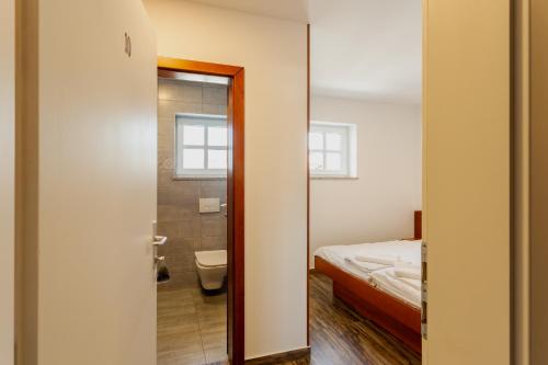 a bathroom with a bed and a toilet in a room at Sobe in apartmaji Triglav - Gostinstvo Tomex in Ilirska Bistrica
