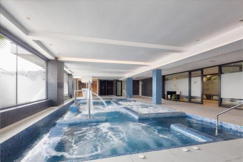 a swimming pool with a fountain in a building at Eurostars Puerto de Ibiza in Ibiza Town