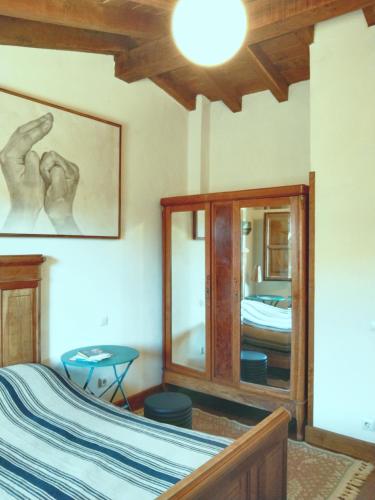 a bedroom with a bed and a mirror at La Casuca de Margot in Agüero