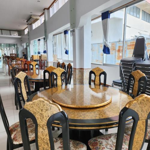 an empty restaurant with tables and chairs at NAVY HOME HOTEL โรงแรมเนวี่โฮม in Mae Sai