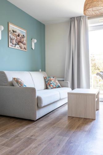 a living room with a couch and a coffee table at Résidence Odalys Les Villas de la Baie in Le Crotoy