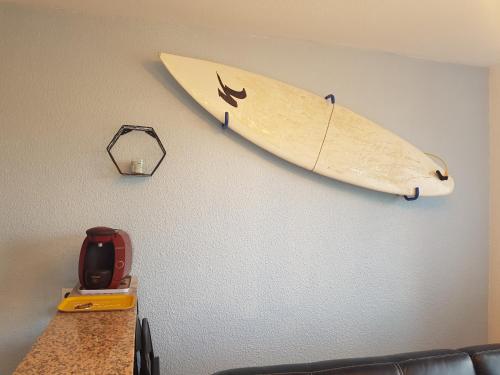 une planche de surf accrochée à un mur dans une pièce dans l'établissement Appart à Seignosse Le Penon, à Seignosse