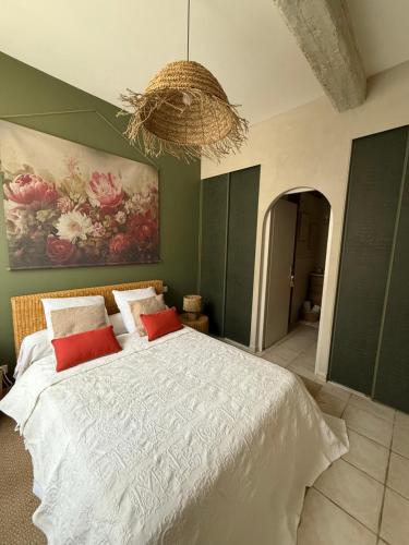 une chambre avec un grand lit avec un tableau au mur dans l'établissement Les gites du tilleul, à Villefranche-de-Lauragais