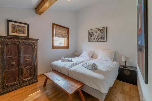une chambre avec un grand lit et un parquet dans l'établissement Tavaillons Apartment - Snow and Trek- Morzine, à Morzine