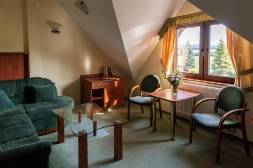 a living room with a couch and chairs and a table at Ośrodek Wypoczynkowy Przystań Energii in Nadole