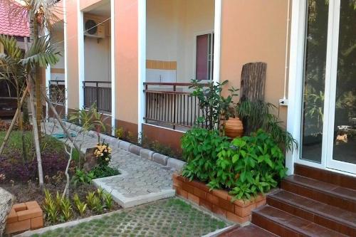 a porch of a house with plants and stairs at M Place Maerim in Chiang Mai