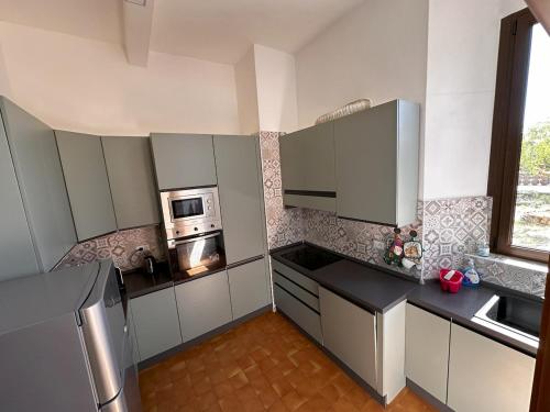 a small kitchen with a stove and a microwave at Dimora PANE in Fubine