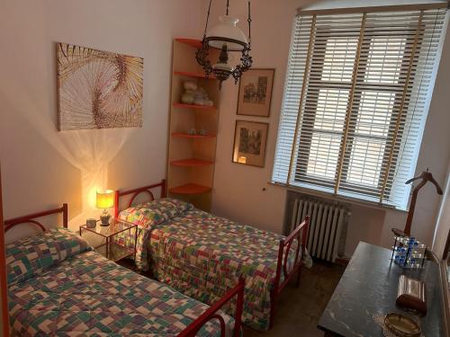 a room with two beds and a table and a window at Dimora PANE in Fubine