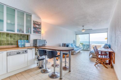 une cuisine avec une table et une vue sur l'océan dans l'établissement Première Ligne Avec Terrasse, à Mauguio