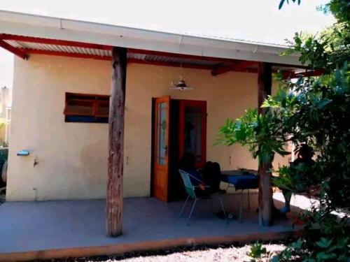 a small house with a door and a table and chairs at Ladismith Lodge in Ladismith