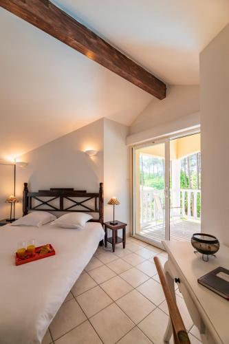 une chambre avec deux lits et un bureau et une fenêtre dans l'établissement Lagrange Vacances - Eden Parc Golf, à Lacanau-Océan