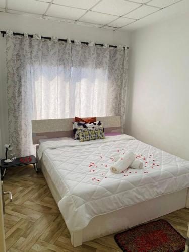 una camera da letto con un grande letto bianco con petali di rose rosse sopra di RAMI Appart a Antananarivo