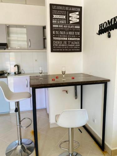 un bar con due sedie e un tavolo in una cucina di RAMI Appart a Antananarivo