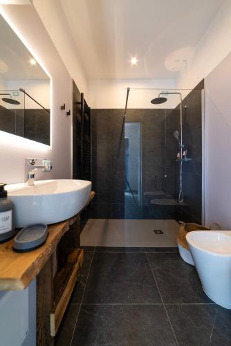 a bathroom with a sink and a shower at Lussari Style Apartments in Camporosso in Valcanale