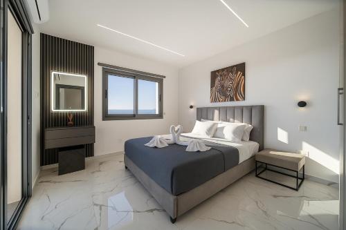 a bedroom with a large bed and a mirror at HiddenGems Residences 202 - The LXR Penthouse - Pool & Beach Steps in Paphos