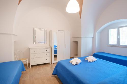 een slaapkamer met 2 blauwe bedden en een spiegel bij Villa della Nonna in Torre Canne