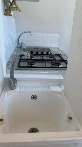 a stove top in a kitchen with a sink at Home Fiesta in Giardini Naxos