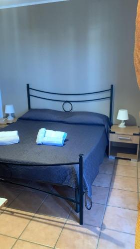 a bedroom with a bed with two towels on it at Home Fiesta in Giardini Naxos