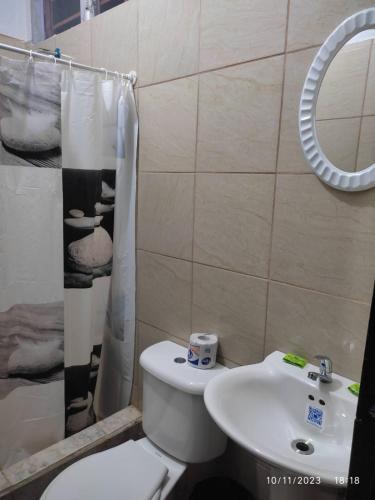 a bathroom with a toilet and a sink and a shower at Cabinas zancudo in Golfito
