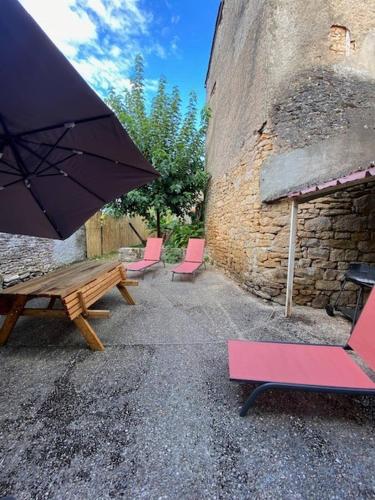 - un groupe de chaises et une table de pique-nique avec un parasol dans l'établissement Jolie maison de vacances centre Gramat, à Gramat
