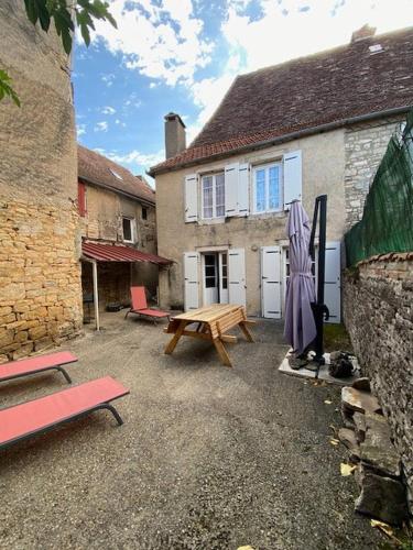 - une terrasse avec une table de pique-nique en face d'une maison dans l'établissement Jolie maison de vacances centre Gramat, à Gramat