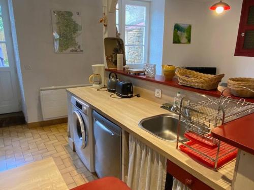 a kitchen with a sink and a washing machine at Jolie maison de vacances centre Gramat in Gramat