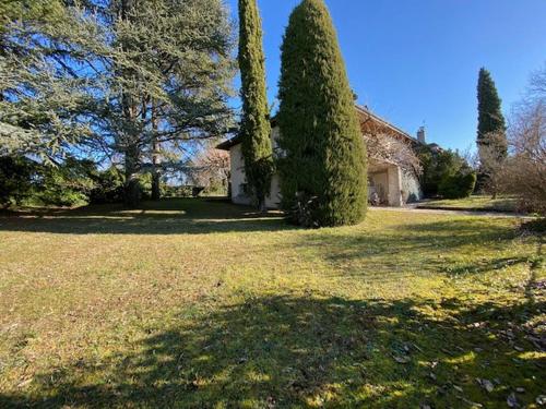 une grande cour avec une maison et un arbre dans l'établissement la maison d'enfance, à Alvignac